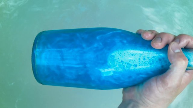 Blue elixir bottle pulled from the water