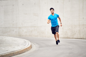 Picture of athletic man during jogging session outdoors in the city