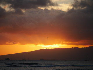 bright orange sun light behind the mountain in Hawaii during sunset