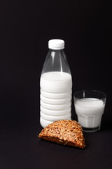 Fresh bottle of milk with black bun.