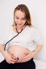 cute young pregnant woman on plans examining in a female consultation. Motherhood, happiness,...