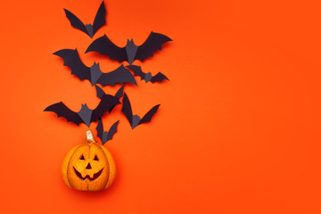 Halloween concept, swarm of bats on background of Halloween pumpkin lantern