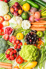 Summer fruits vegetables berries background, apples cherries peaches strawberries cabbage broccoli cauliflower squash tomatoes carrots spring onions beetroot, top view, selective focus