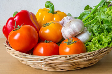 Organic vegetables in the wicker basket on wooden background