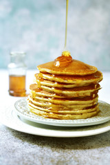Stack of homemade delicious pancakes with maple syrup for a breakfast.