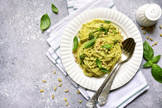 Spaghetti pasta with basil pesto and pine nuts.Top view with copy space.