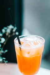 Orange fresh squeezed juice with ice in the restaurant. Close up, copy space