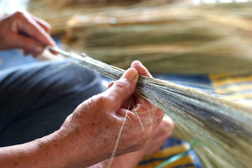 women's hand is making thai broom