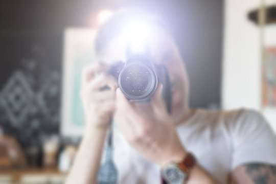 A man takes pictures on a camera with a flash