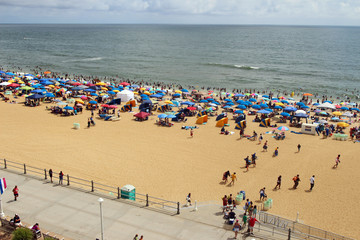 A view of a crowded beach and boardwalk. Virginia Beach on Independence Day, Fourth of July 2018,...