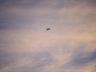 airplane flying in the sky during sunset clouds