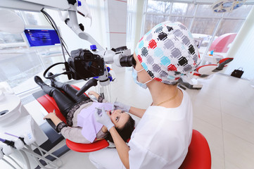 Modern medical equipment in a dental clinic. The doctor examines the oral cavity and teeth of the...