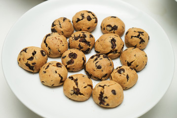 Cookies and sweet biscuits on white plate background, top view 