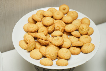 Cookies and sweet biscuits on white plate background, top view 