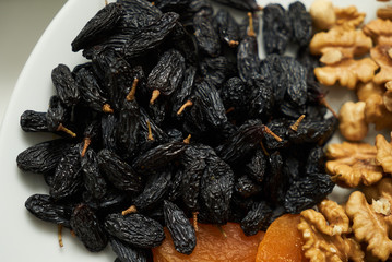 Mix of dry nuts and fruits. Composition with dried fruits and assorted nuts on white plates, top view