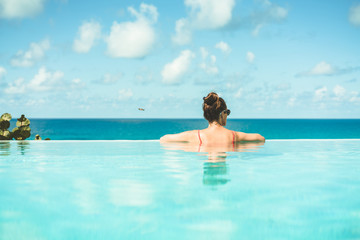 Woman relaxing on vacation in infinity edge pool