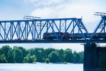 Naklejka premium The train travels along the railway bridge across the river.