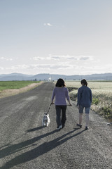 Fototapeta premium Mother and daughter walking dog.