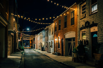 Fototapeta premium String lights over Chapel Street at night in Butchers Hill, Baltimore, Maryland