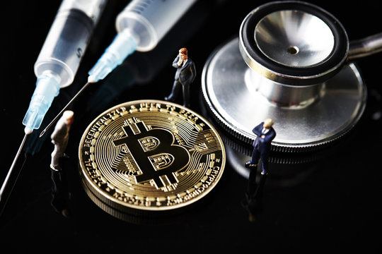 Bitcoin with miniature men and medical equipment 