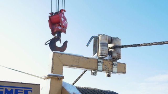 steel wire rope moves between cable guide rollers on support by crane hook