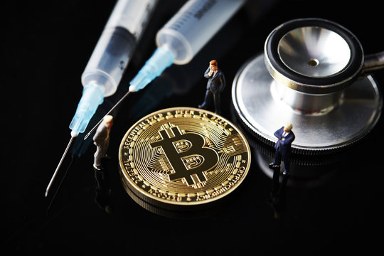 Bitcoin with miniature men and medical equipment 