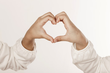 A little girl hand make a heart isolated white.