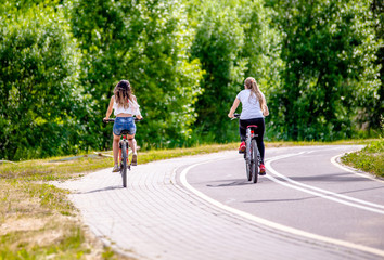 Fototapeta premium Cyclists ride on the bike path in the city Park 