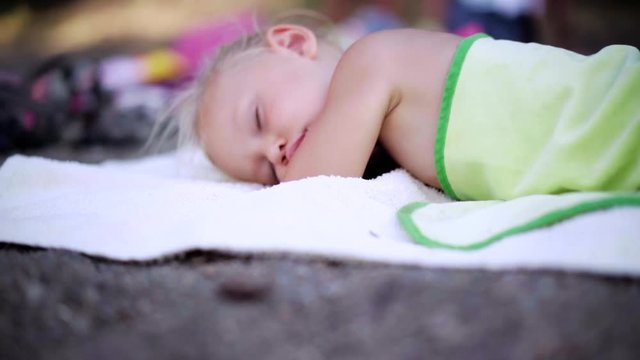 Small cute baby sleeping on the beach of the sea on a white blanket. Cute Child sleeps.