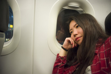 lifestyle portrait of young beautiful and sweet Asian Chinese tourist woman sleeping on plane during long flight feeling tired taking a nap in holidays travel