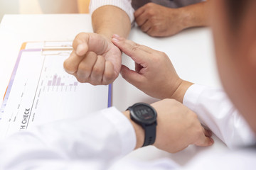 Doctor check patient blood pressure in office.