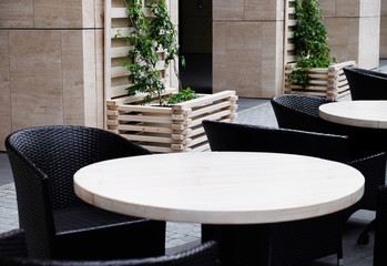 Street view of a Cafe terrace with empty tables and chairs