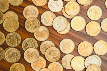 Stack of coin on wooden working table, business and finance concept.
