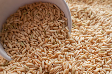 Raw brown rice in a bowl. top view food background