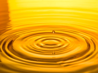 close up of a drop oil on a yellow background