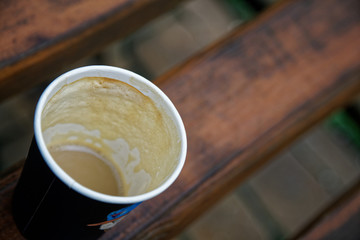 Coffee cup on wooden bench, productive morning.