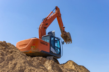 Excavator at the construction site loads the sand