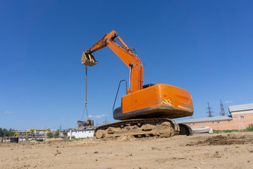 Excavator moves a concrete ring for a sewer well