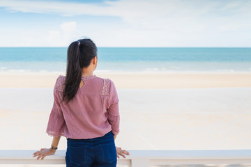 Traveler Asian woman feeling happy on the beach to the summer sea background.Concept of relax on vacation holidays.