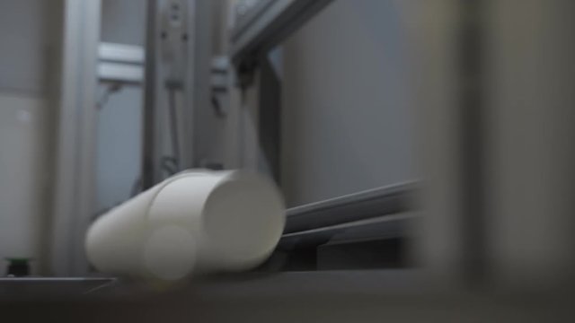 Paper cups are moved to packing area by pneumatic mail. Eco-friendly production of disposable crockery from paper or cardboard. Factory or plant indoor. Cup for tea or coffee to go. Closeup