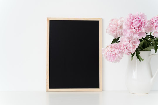 White portrait frame mock up with a pink peonies beside the frame, overlay your quote, promotion, headline, or design, great for small businesses, lifestyle bloggers and social media campaigns