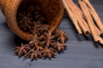 Anise star and cinnamon on wooden background, close up shot with selective focus