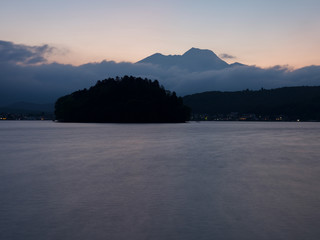 夕焼けの湖畔にて、山には雲が棚引いて、島と湖面が夕焼け色にそまる。。