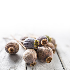 Poppy heads freely lying on a wooden board.