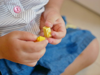 Interlocking plastic bricks (toy) in baby's hands - playing interlocking bricks provides opportunity for building fine motor skill and sense of acchievement in babies