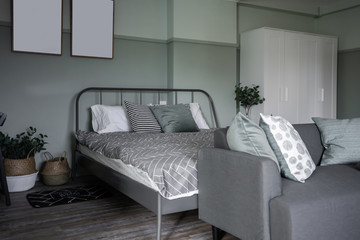 Cozy green bedroom corner with wooden frames decoration and modern gray metal bed  in modern vintage style / Cozy Interior concept
