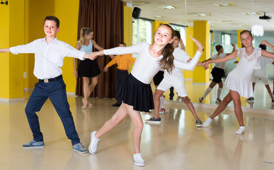 Fototapeta na wymiar Positive children are dancing rock-n-roll in pairs