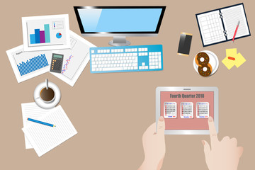 Top view of the office workplace with hands  holding tablet with a calendar for fourth quarter of 2018 year on the screen