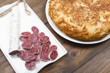Spanish potato omelette next to fuet. Typical spanish food.