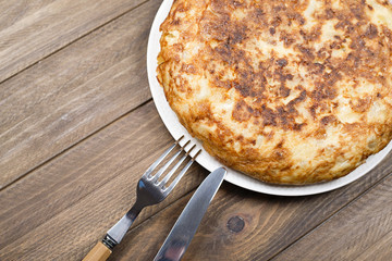 Potato omelette on rustic brown wooden background. Typical spanish food.